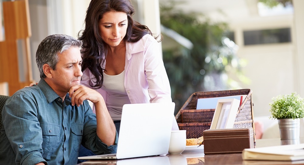 couple working on insurance exam on laptop