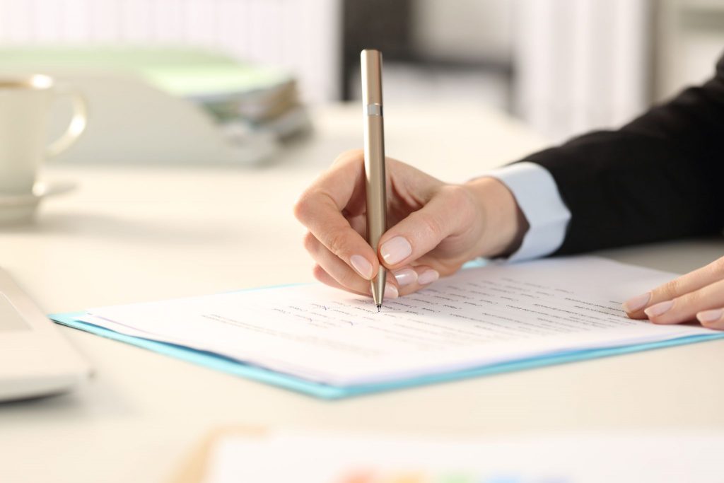 business woman hands filling out form sitting on a desk in the office