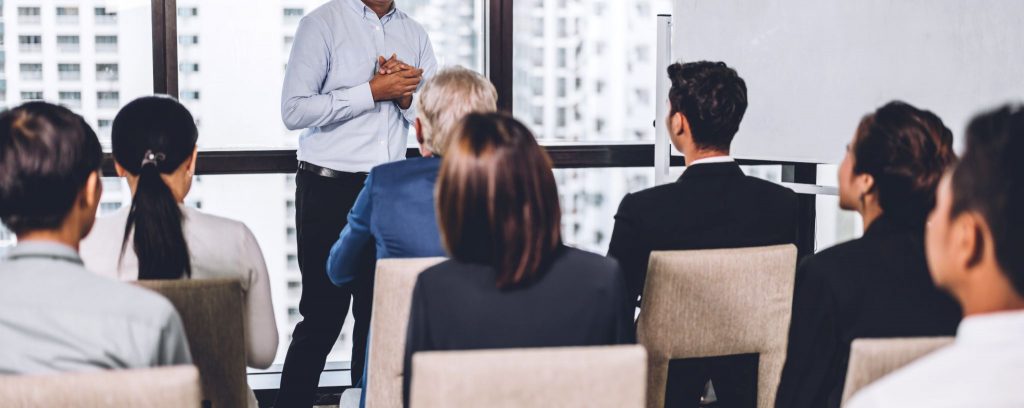 Businessman standing in front of group of people in consulting meeting conference seminar