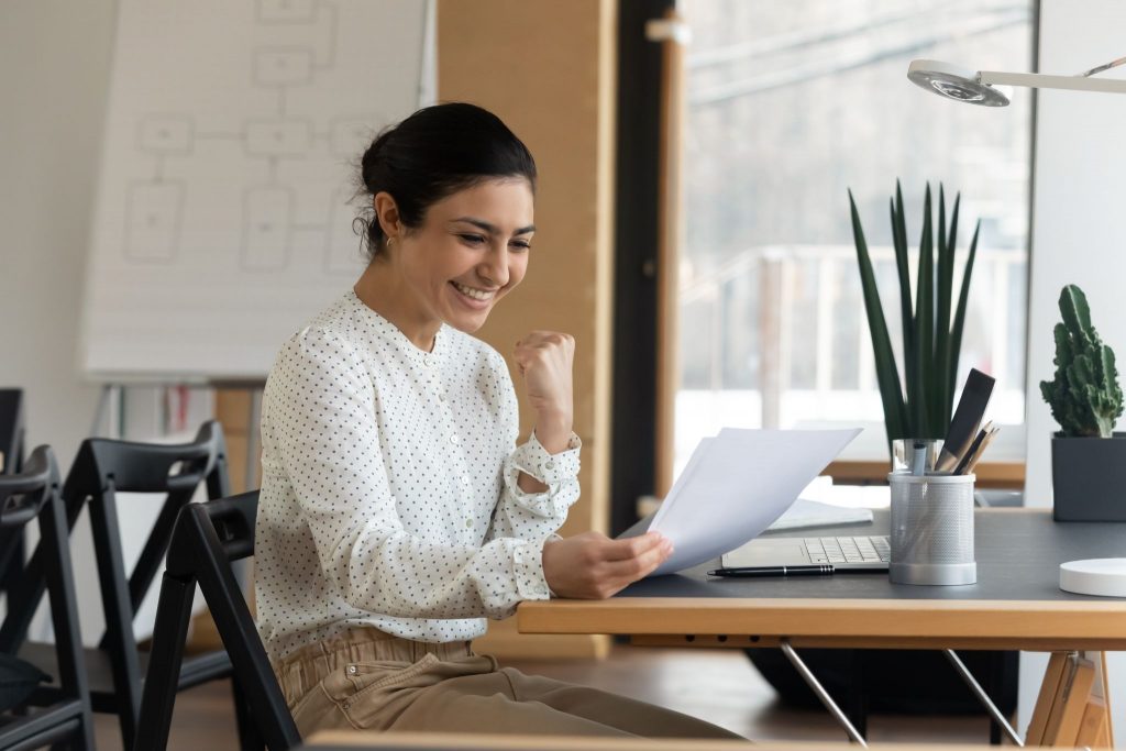 Happy woman reading paper letter