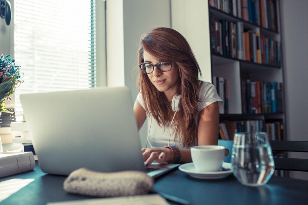 Young female student using laptop and learning online.