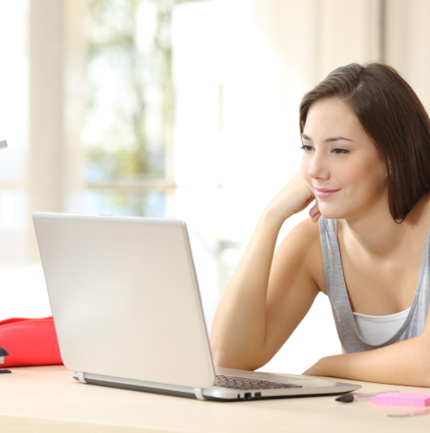 High school student looking at laptop screen at home