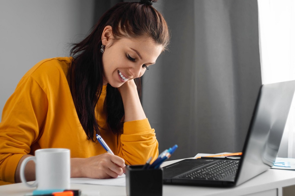 Woman taking notes during her insurance exam prep course