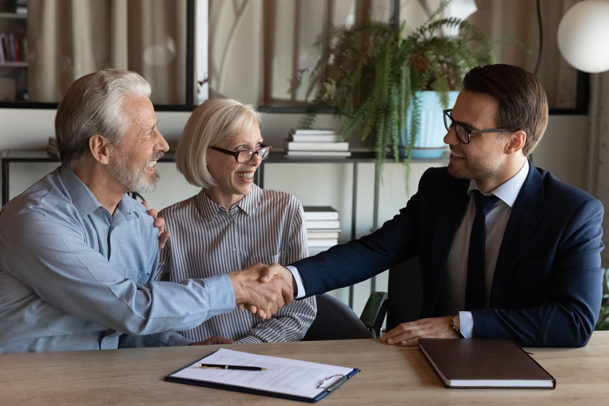 Property and casualty insurance agent helping a couple in his office
